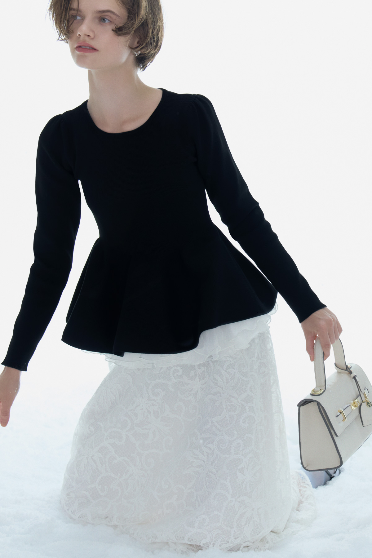 ペプラムドッキングニットプルオーバー、チュール刺繍フレアスカート、ビジューリボンイヤリング、ビジューツイストバックルハンドバッグ、ロゴバックル付きバックストラップミュールの着用イメージ