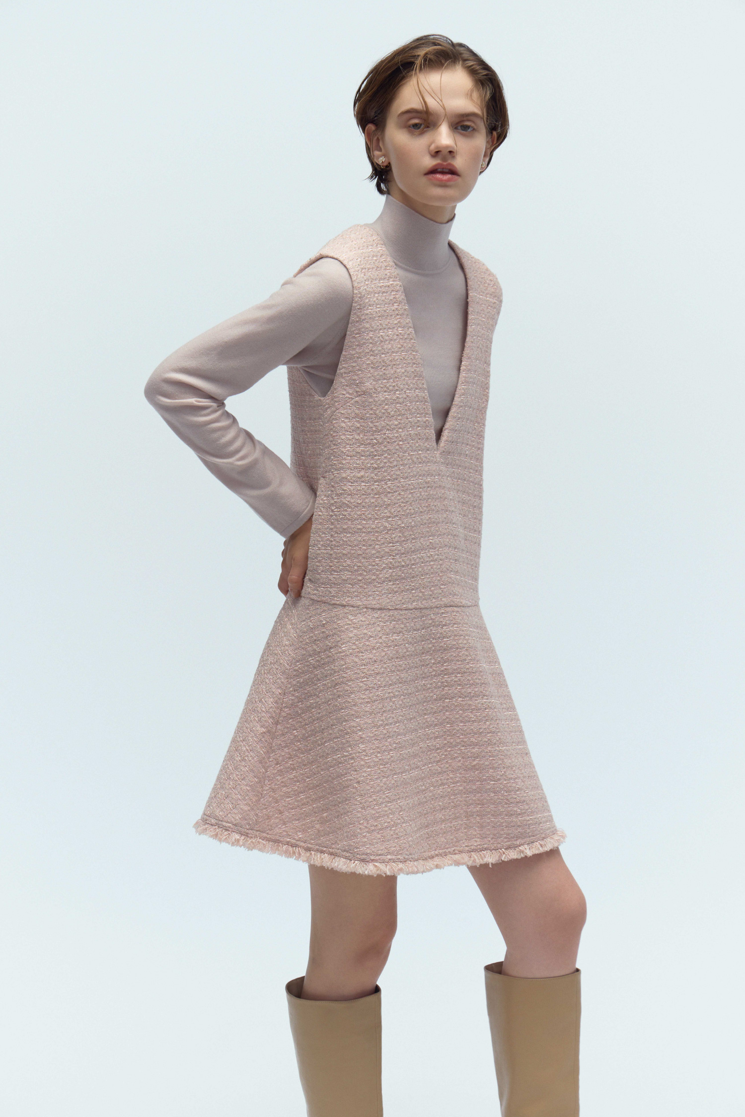 ジャンスカセットアップ、フラワービジューPetitイヤリング、ロゴメタル付きロングブーツを着用した女性のイメージ