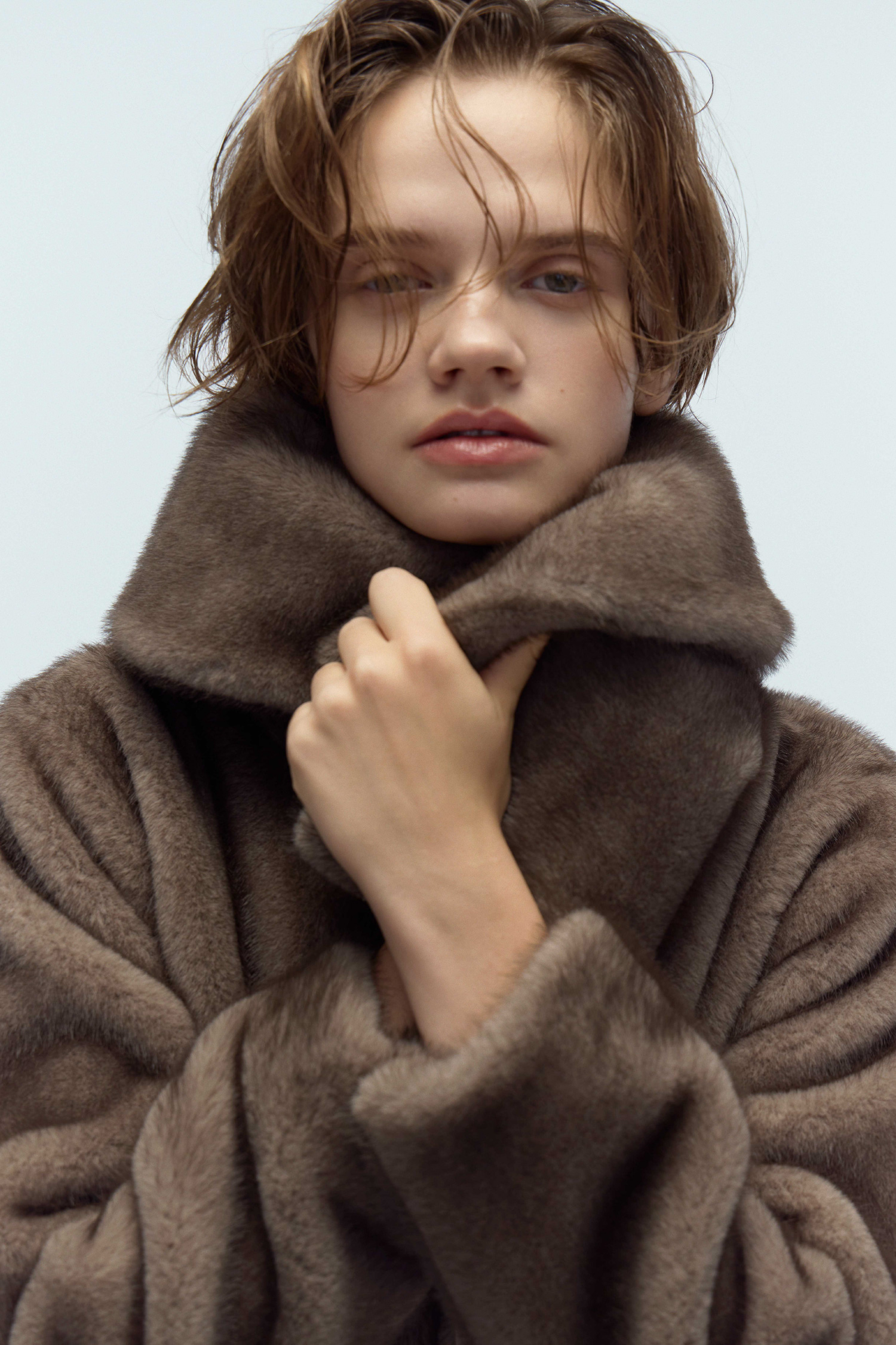 ブラウン色のビッグカラーペプラムファージャケットを着用したモデル画像