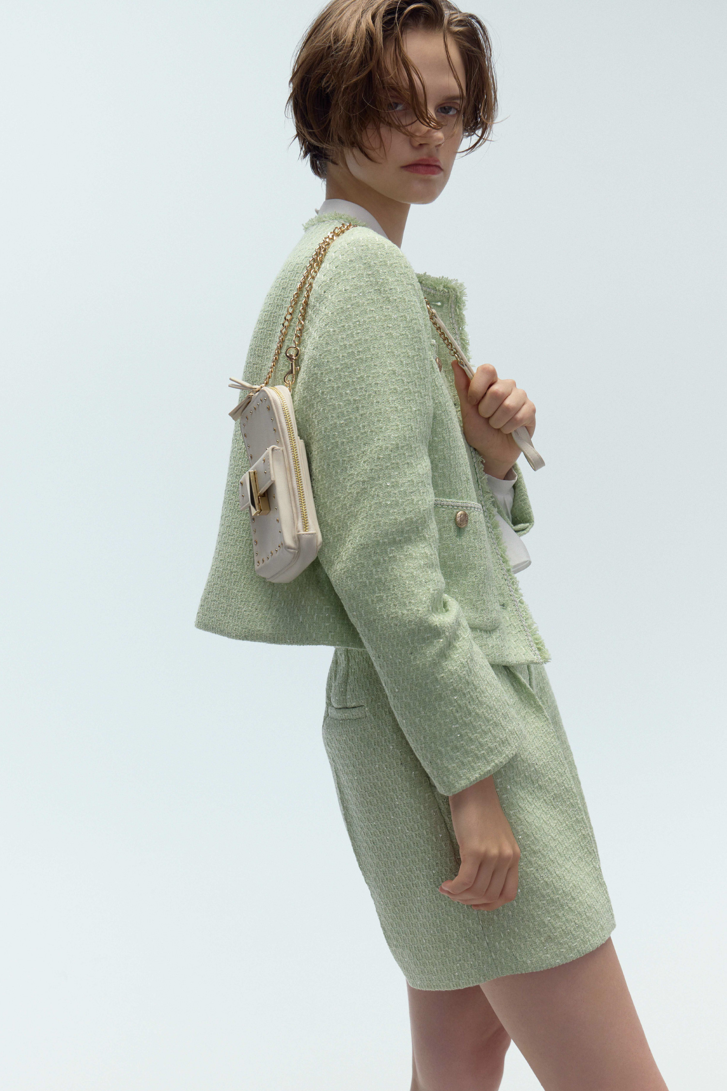 フリンジツイードジャケット、ビッグリボンセミシアーブラウス、バリエーションショートパンツ、リュタンビジュースタッズマルチショルダー、ロゴチャーム付きストレッチショートブーツの着用イメージ