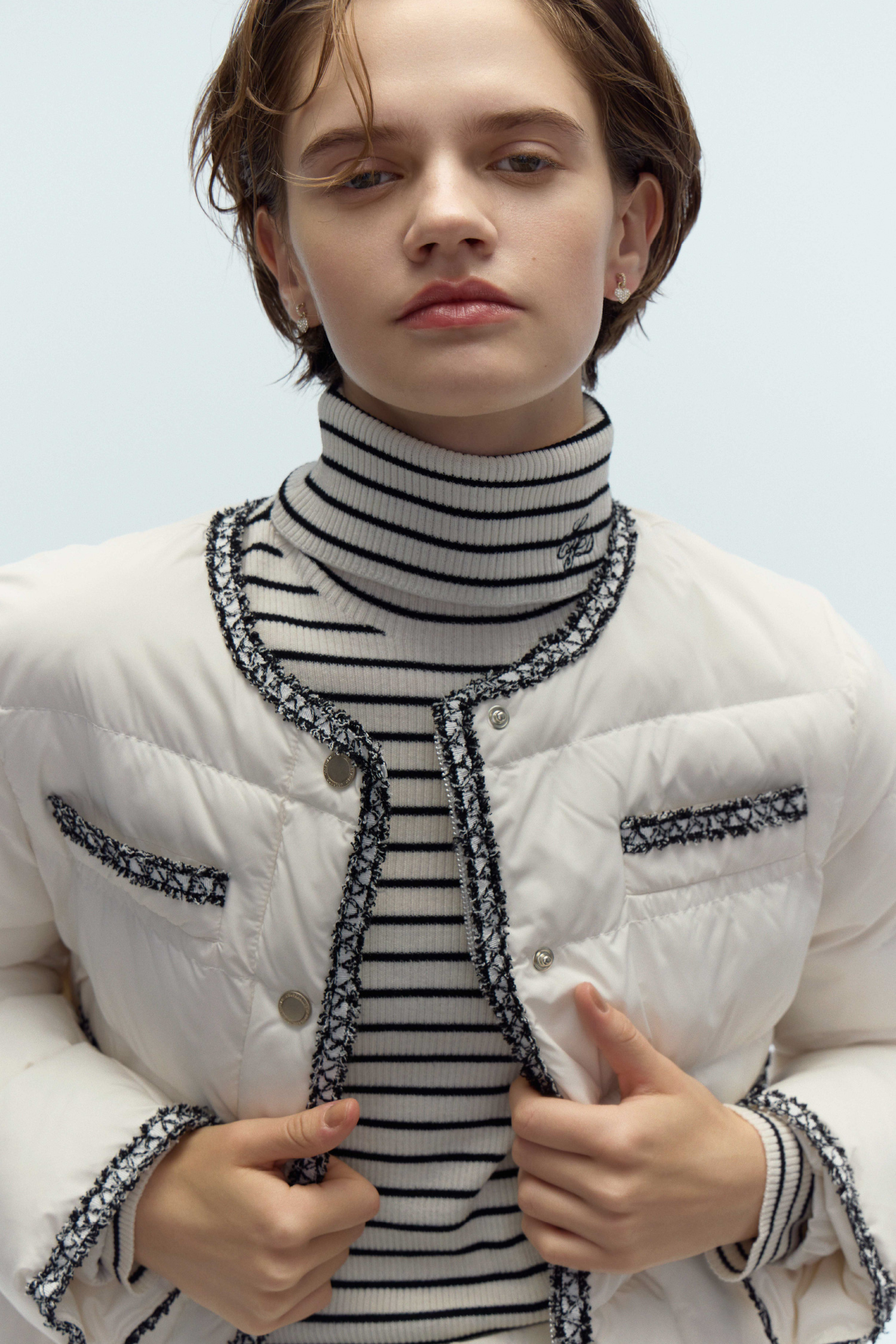 トリムデザインキルティングジャケット、カリグラフィー刺繡シルク混リブニットプルオーバー、パヴェビジューハートピアスを着用したモデル画像