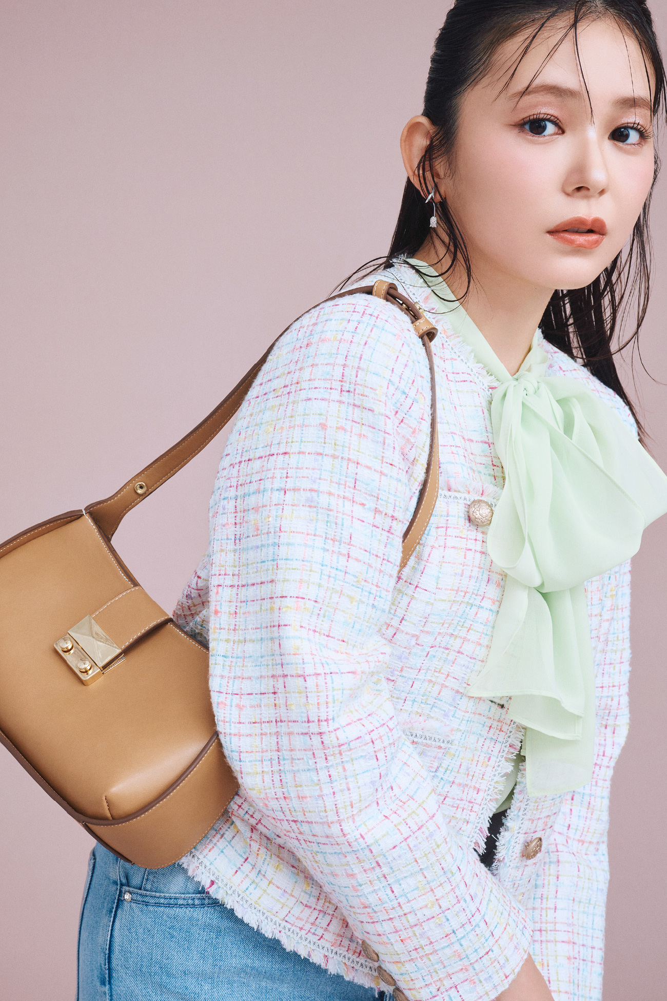 フリンジツイードジャケット、ボウタイリボンハーフスリーブブラウス、ハイウエストフレアデニムパンツ、2WAYワンハンドルショルダーバッグを着用した女性のイメージ