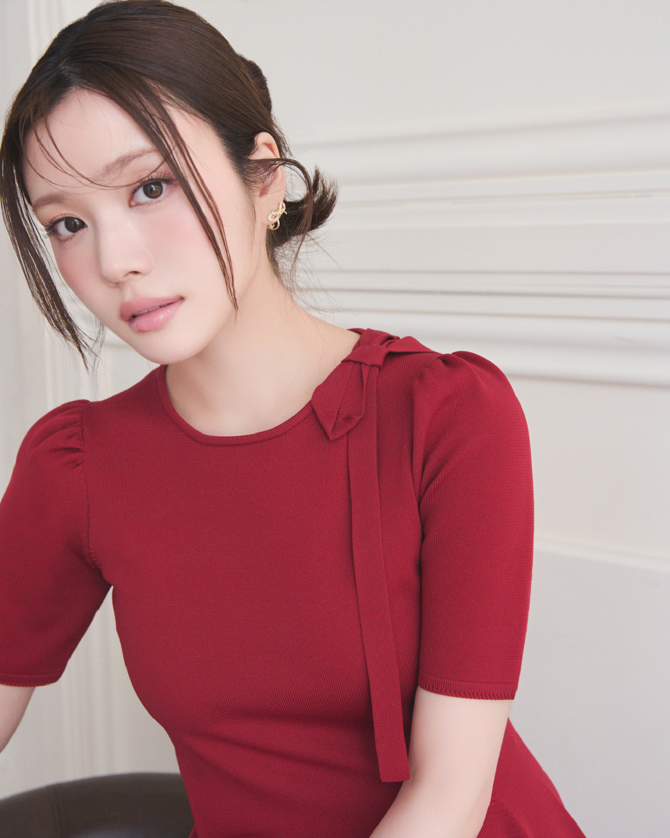赤色のネックリボンホールガーメントワンピースを着用した女性のイメージ