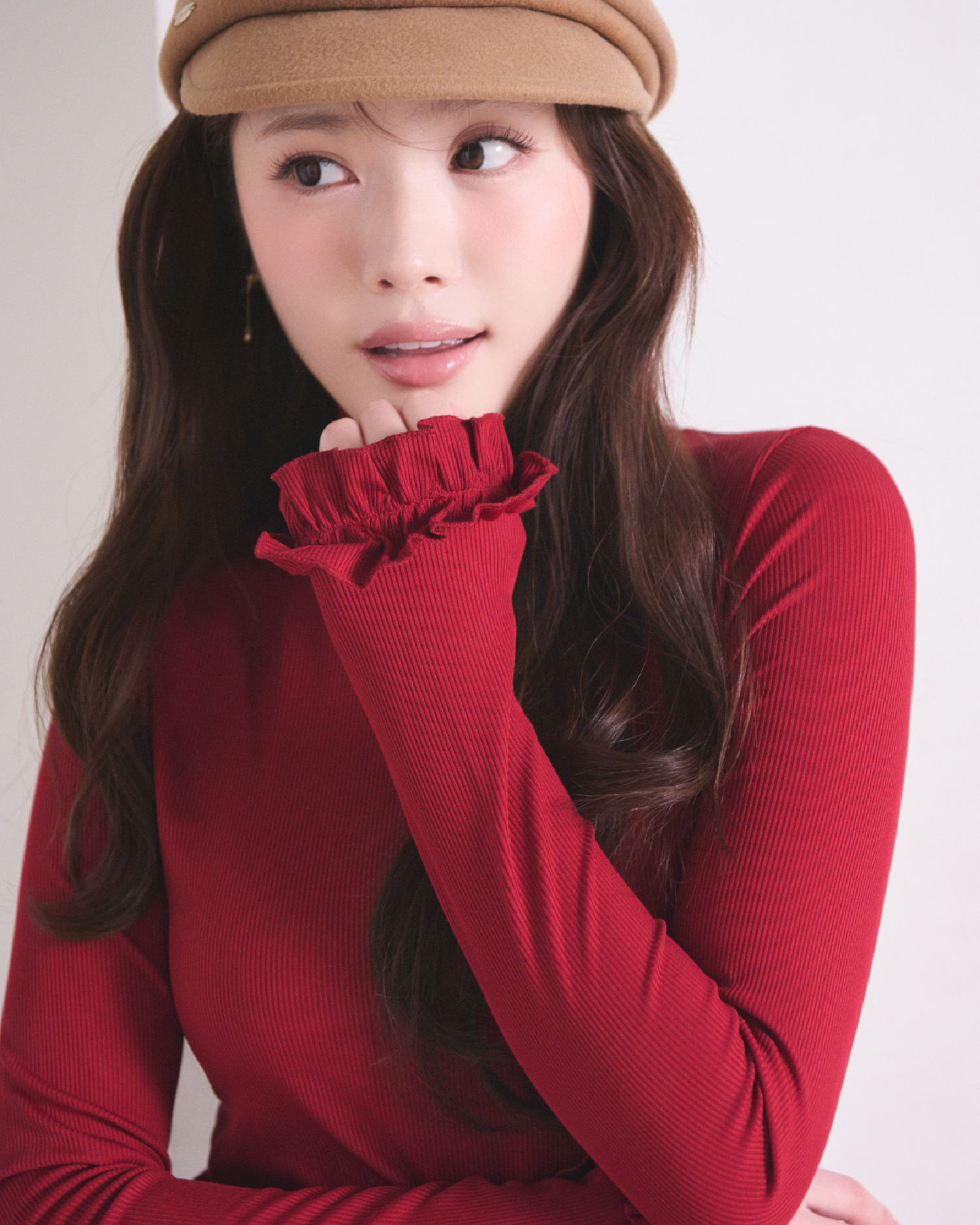 赤色のフリルスリーブタートルトップスとメタルプレート付キャスケットを着用したモデル画像