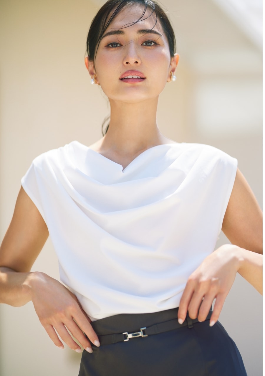 白いトップスを着た女性が正面を向いている画像