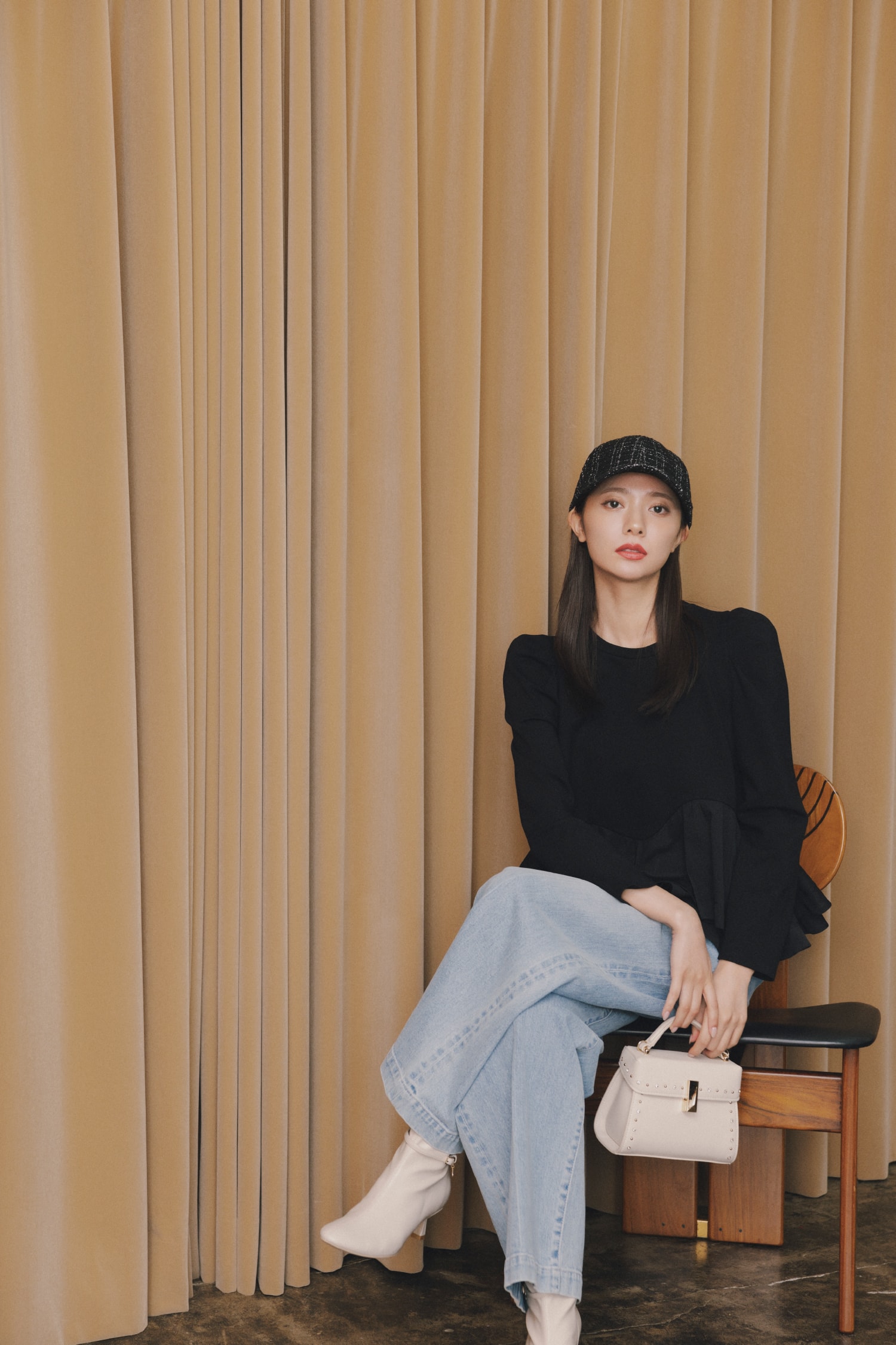 黒いトップスにジーンズを着た女性が正面を向いている画像