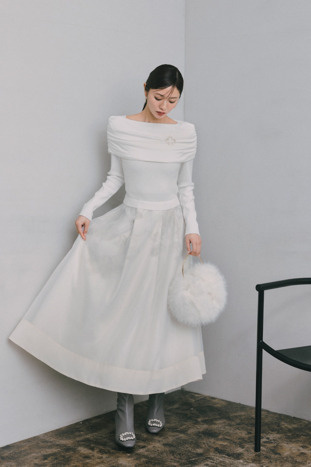白いロングスカートのセットアップを着た女性が正面を向いている画像