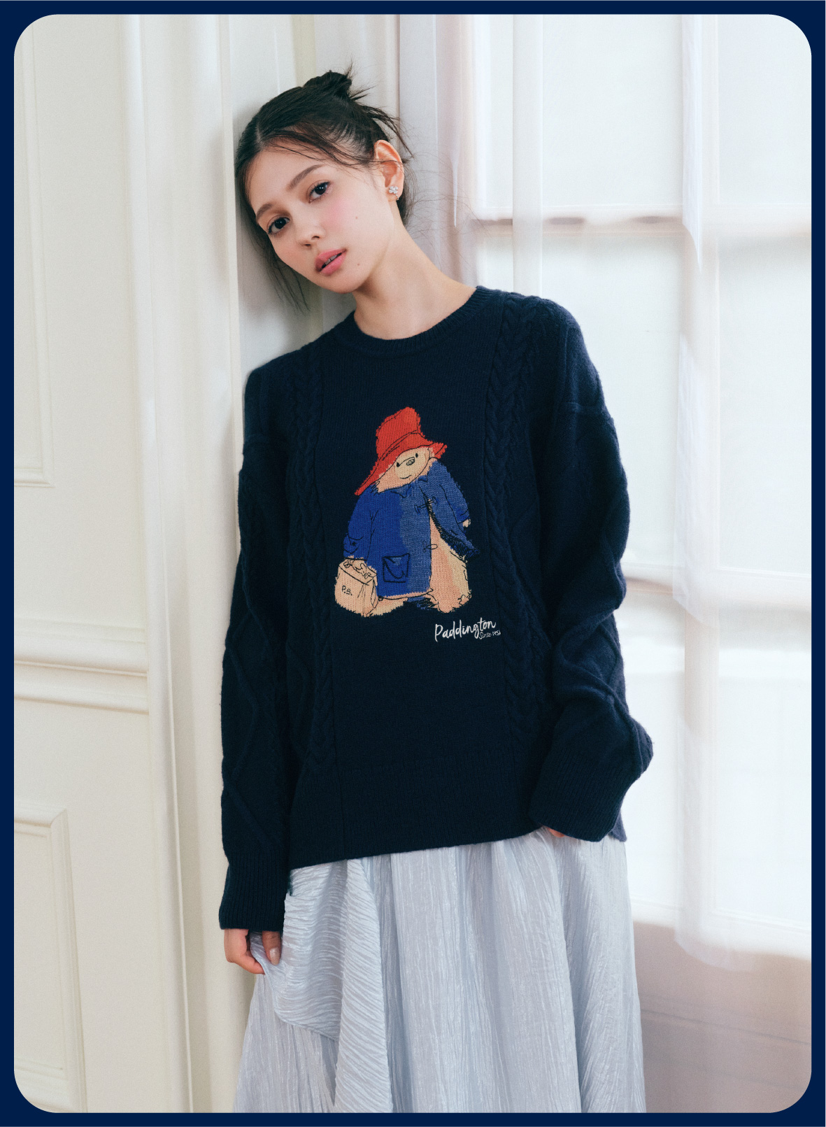 【パディントン™×CELFORD】ケーブルニットプルオーバーとシャイニーアシンメトリースカートを着用したモデル画像