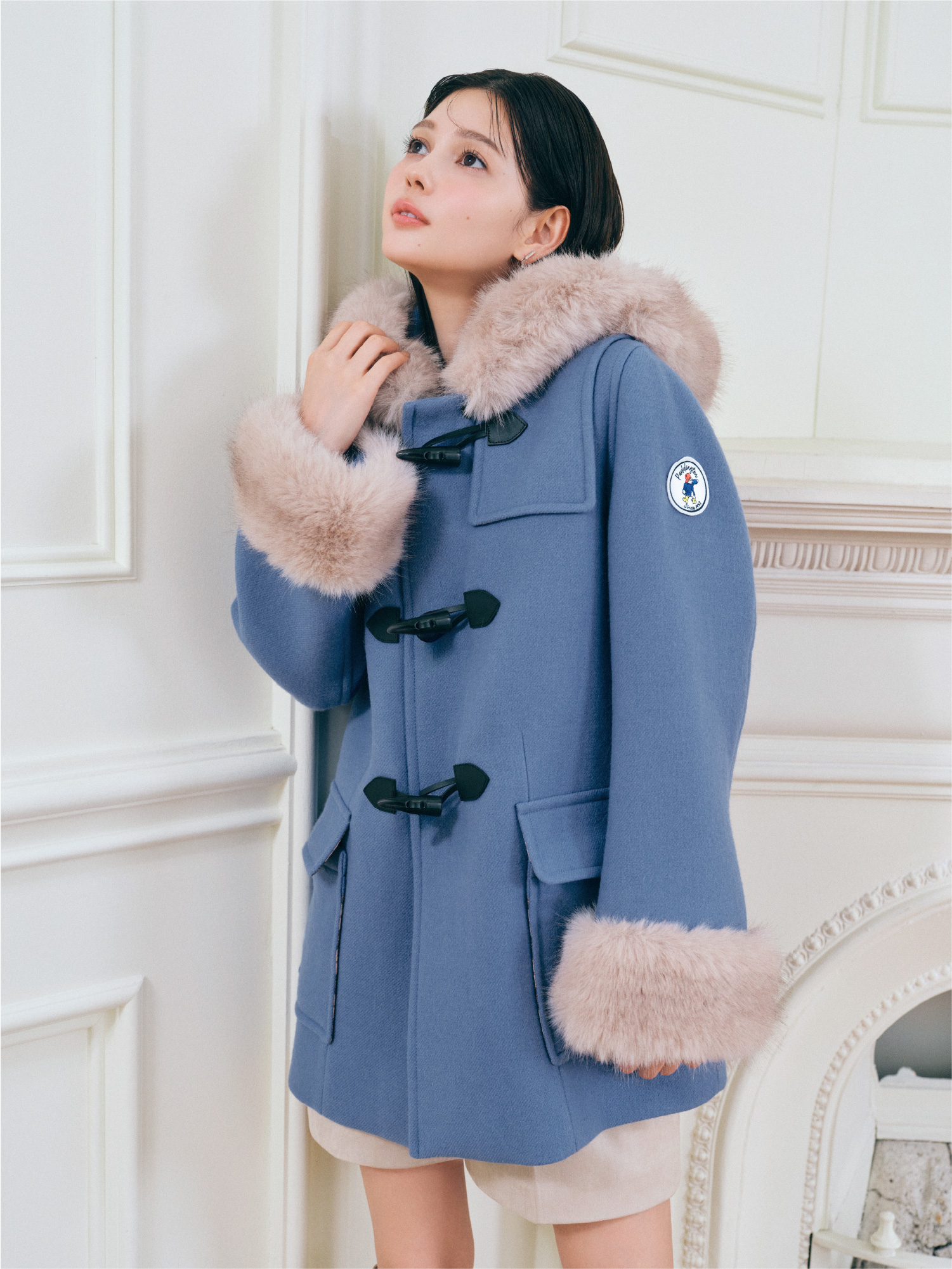 ブルー色の【パディントン™×CELFORD】ダッフルコートとアイボリー色のバリエーションショートパンツの着用イメージ