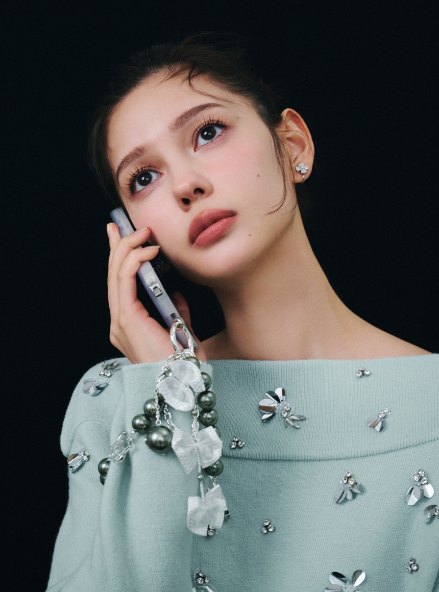 ロゴメタル付きパールチャームストラップを着用したモデル画像