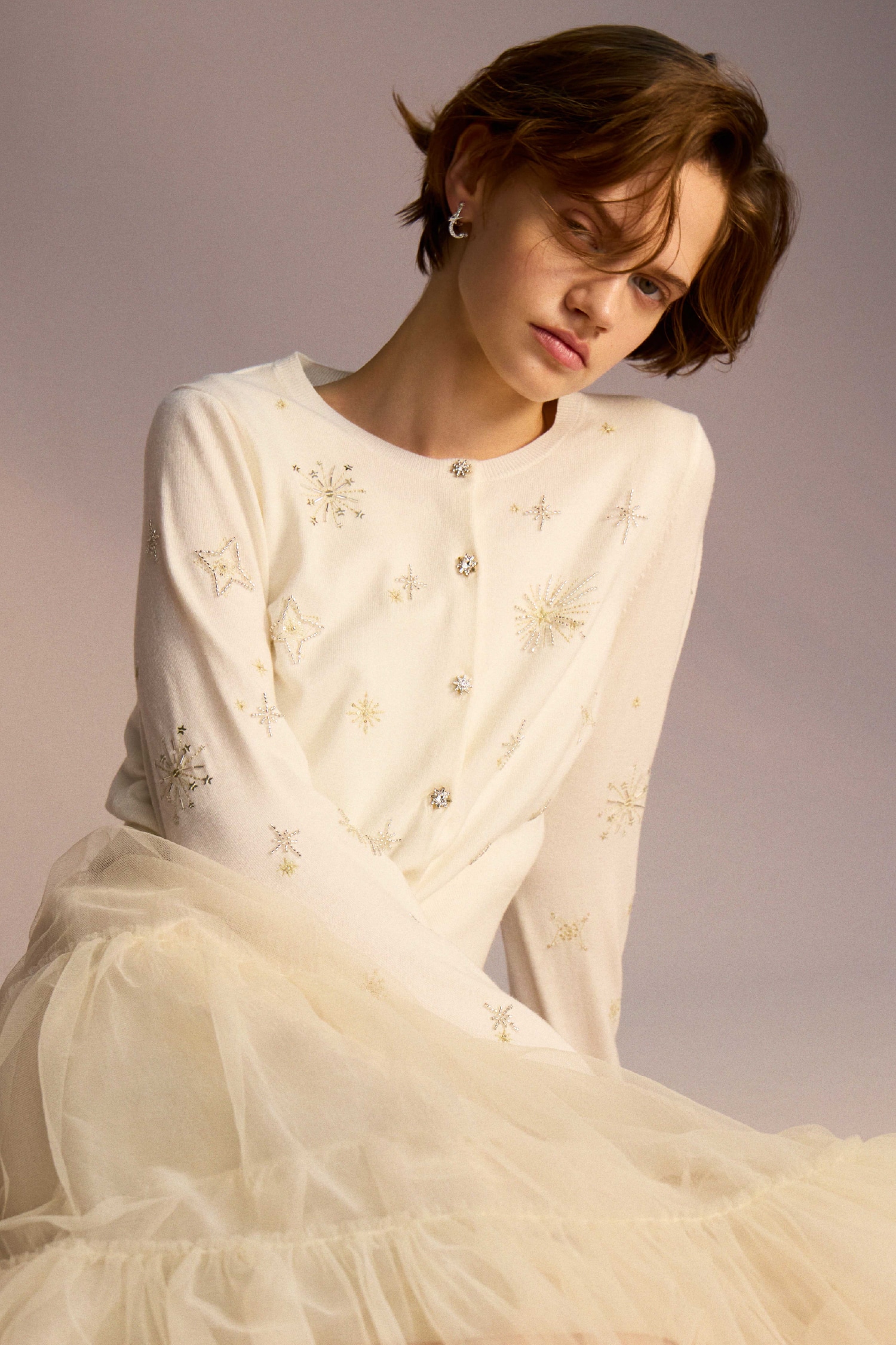 白のスターリー刺繍ニットアンサンブル・アイボリーのチュールティアードスカート・スターリービジューイヤリング・リボンクリップ付きパンプスの着用例