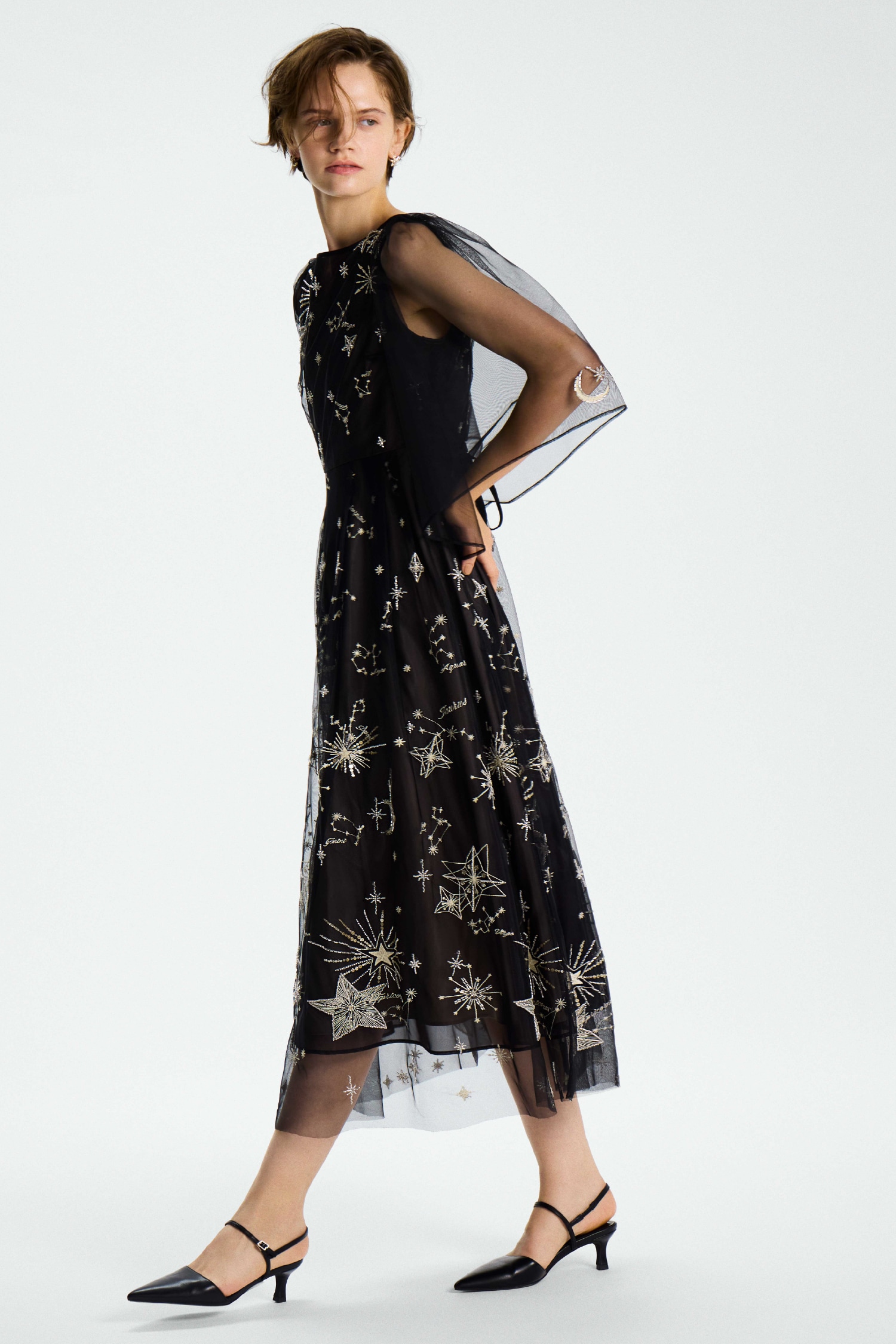 黒のスターリーチュールドレス・金のスターリービジューイヤリング・黒のロゴバックル付きバックストラップミュールの着用例