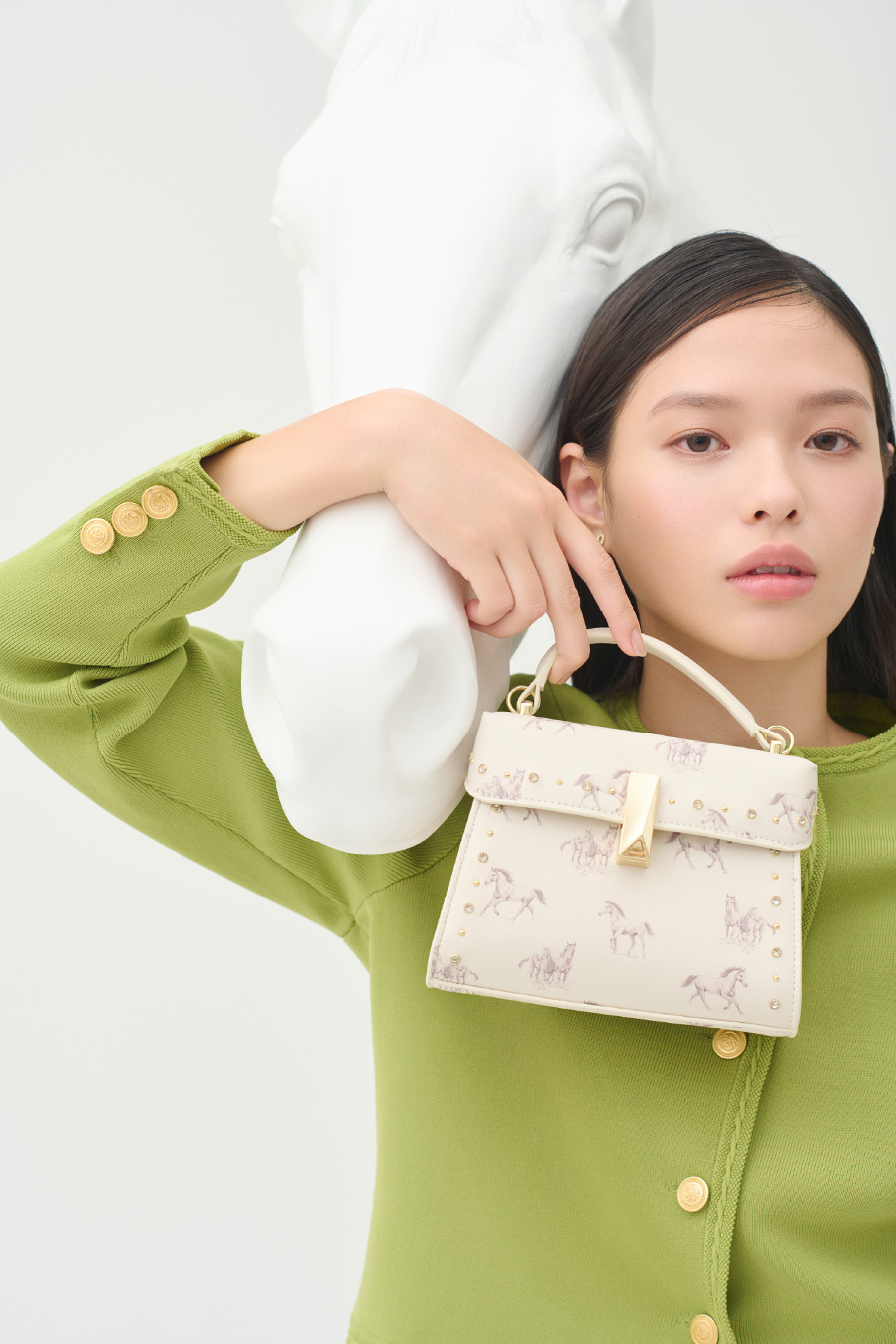 トリム総針カーディガンと【リュタン】ビジュースタッズポシェットを着用したモデル画像