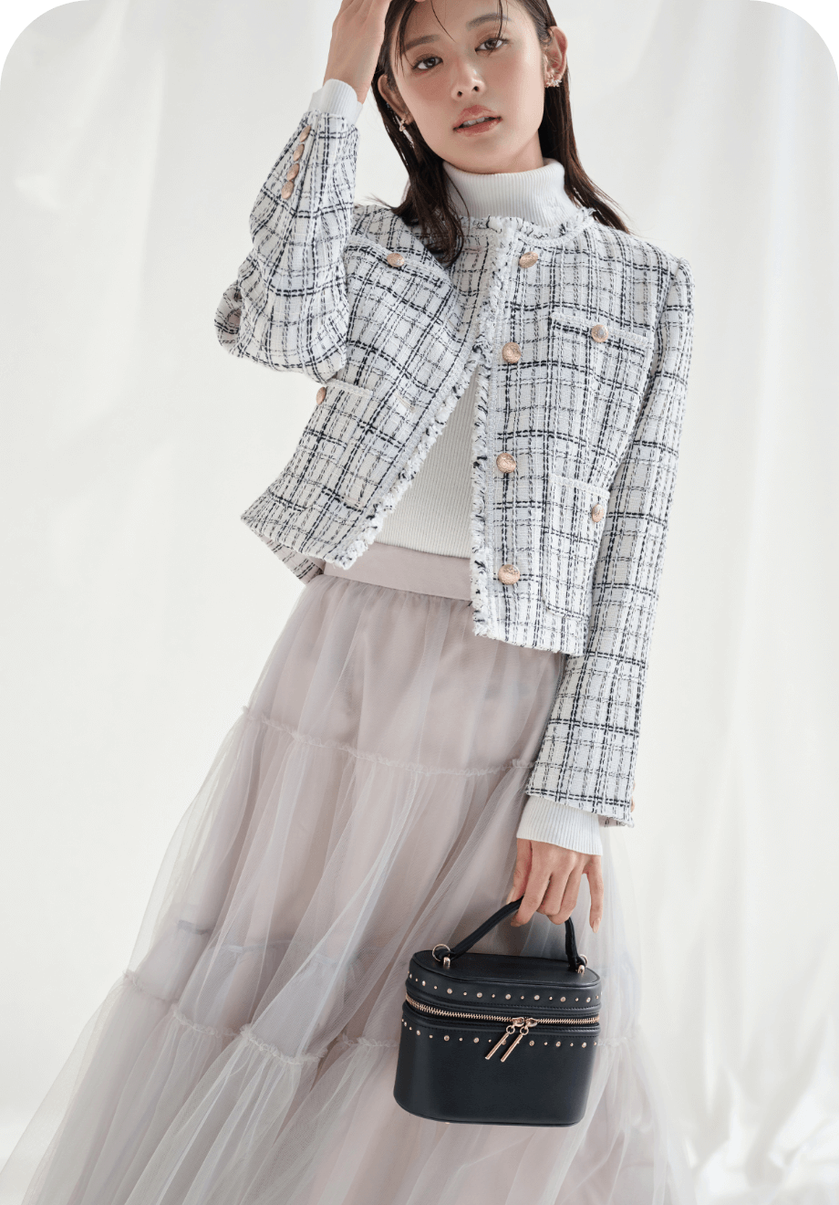 アイボリー色のフリンジツイードジャケットとライトグレー色のチュールティアードスカートを着用したモデル画像