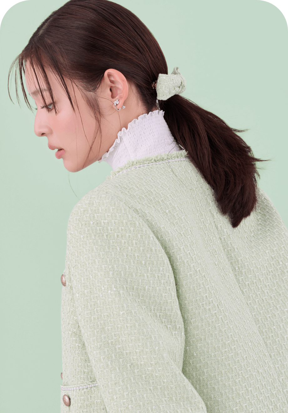 ミント色のフリンジツイードジャケットとロゴメタル付きツイードリボンバレッタ、シルバーのフラワービジューPetitイヤリング、白色のシャーリングカットソートップスを着用した女性の後ろ姿