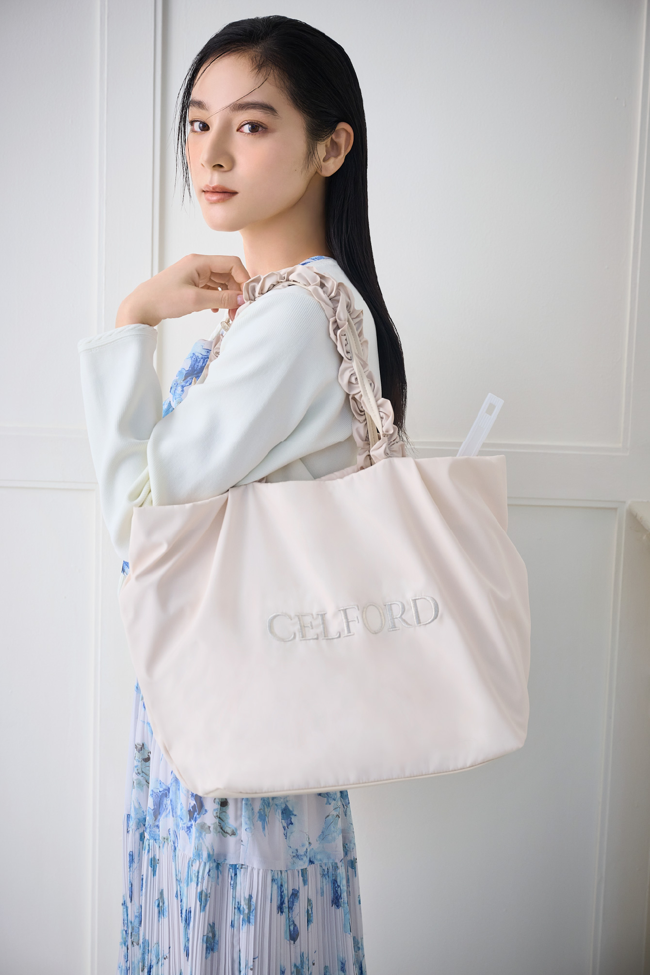 トリム刺繍カーディガン、マーブルフラワープリントワンピース、【プリュム】フリルラメ刺繍トートバッグ（wide）を着用した女性の横の姿イメージ