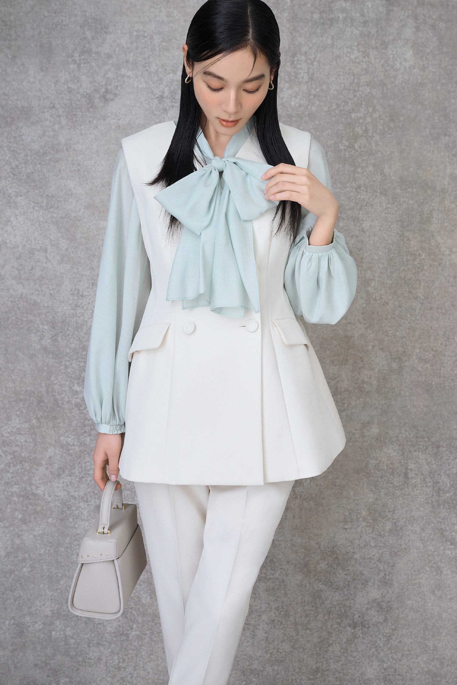アイボリー色のペプラムセットアップ、ミント色のビッグリボンセミシアーブラウス、【リュタン】ビジュースタッズポシェット（Ｍ）を着用したモデル画像