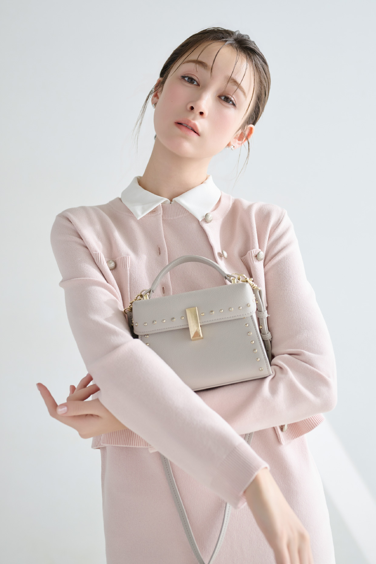 襟付きニットワンピースセット、Cロゴビジューパールプチピアス、【リュタン】ビジュースタッズポシェットを着用した女性のイメージ
