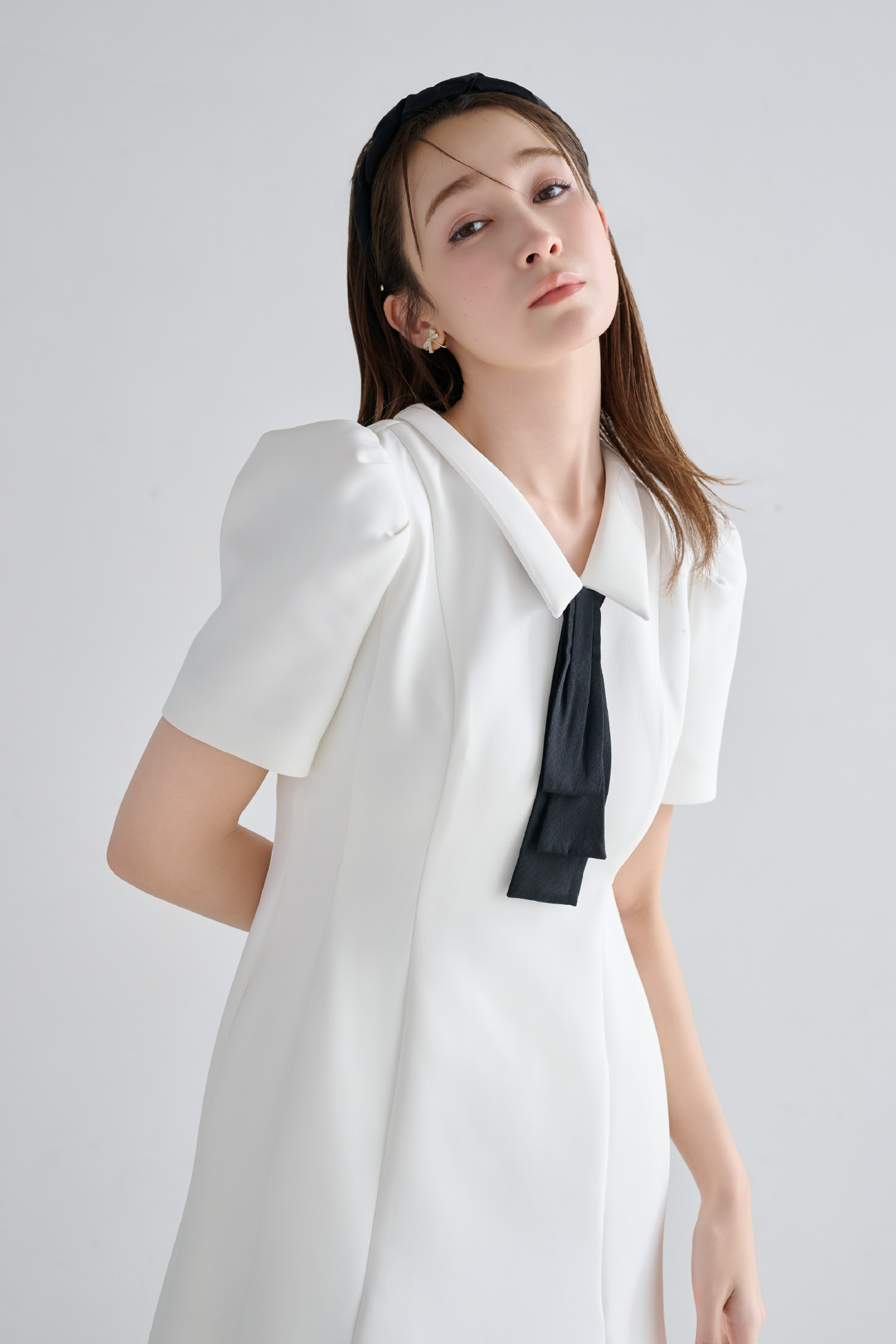 白色の【WEB限定カラー】デタッチャブルポンチマーメイドワンピース、フリルカチューシャ、リボンビジューイヤリングを着用したモデル画像