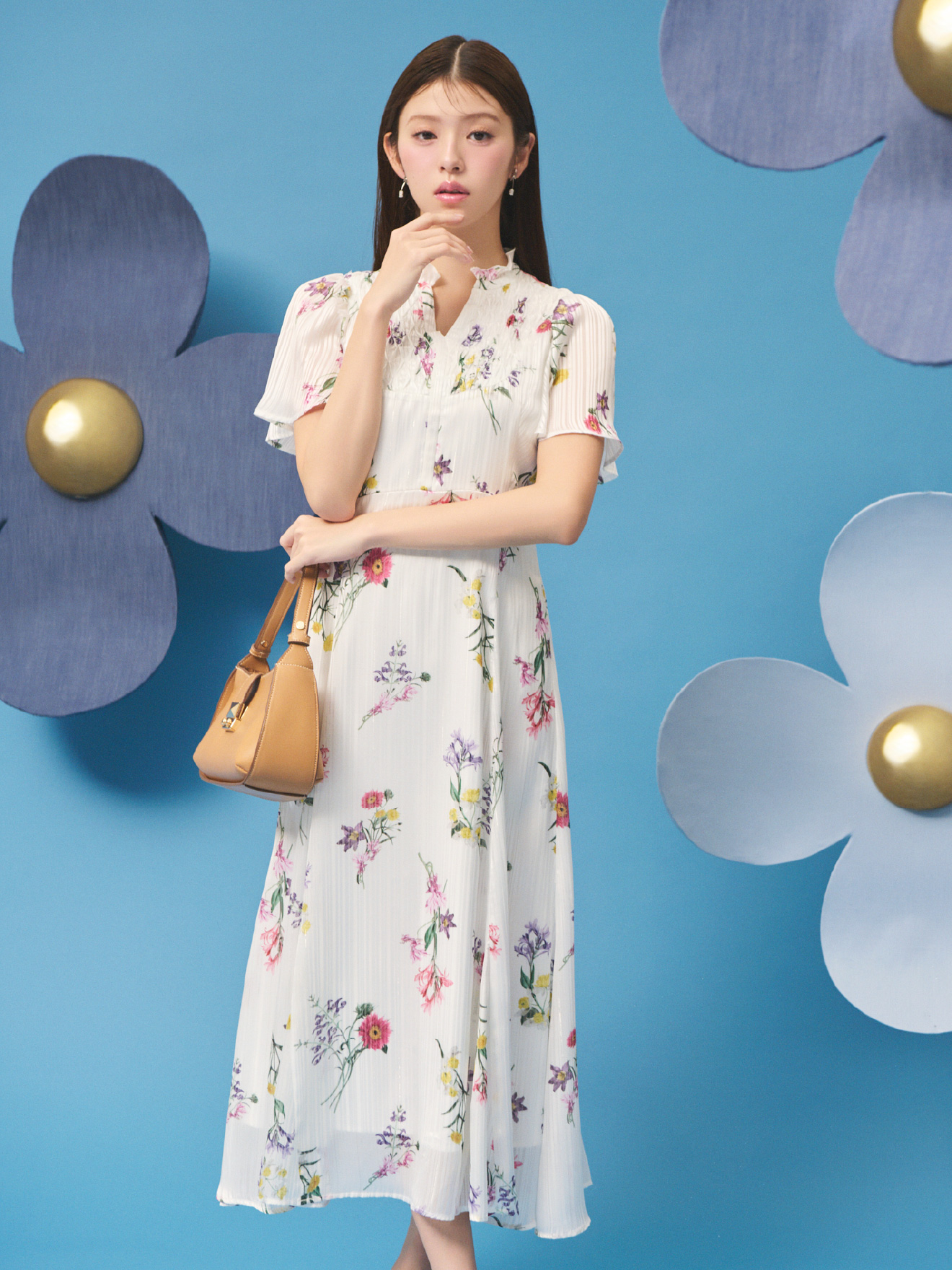 白背景の花柄のボタニカルプリントワンピースとキャメル色の2WAYワンハンドルショルダーバッグを着用した女性のイメージ