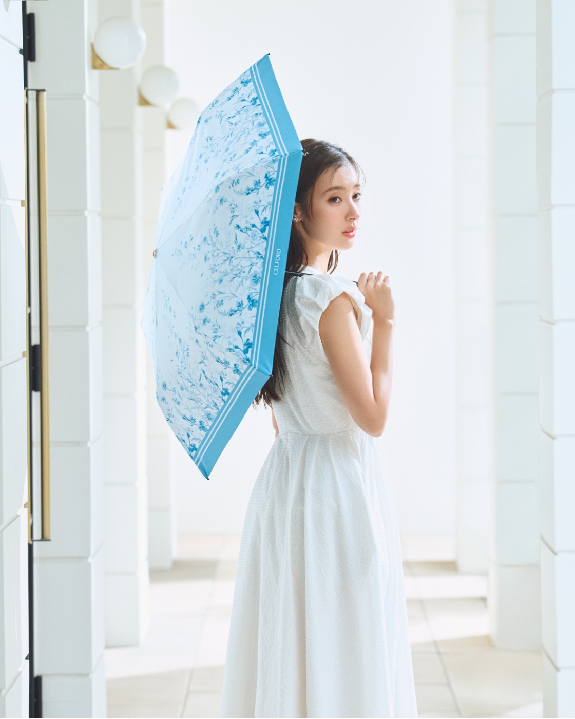 バルーンスリーブシャツワンピース、フラワープリントコラボレーション日傘、ビジューチェリーイヤリングを着用した女性