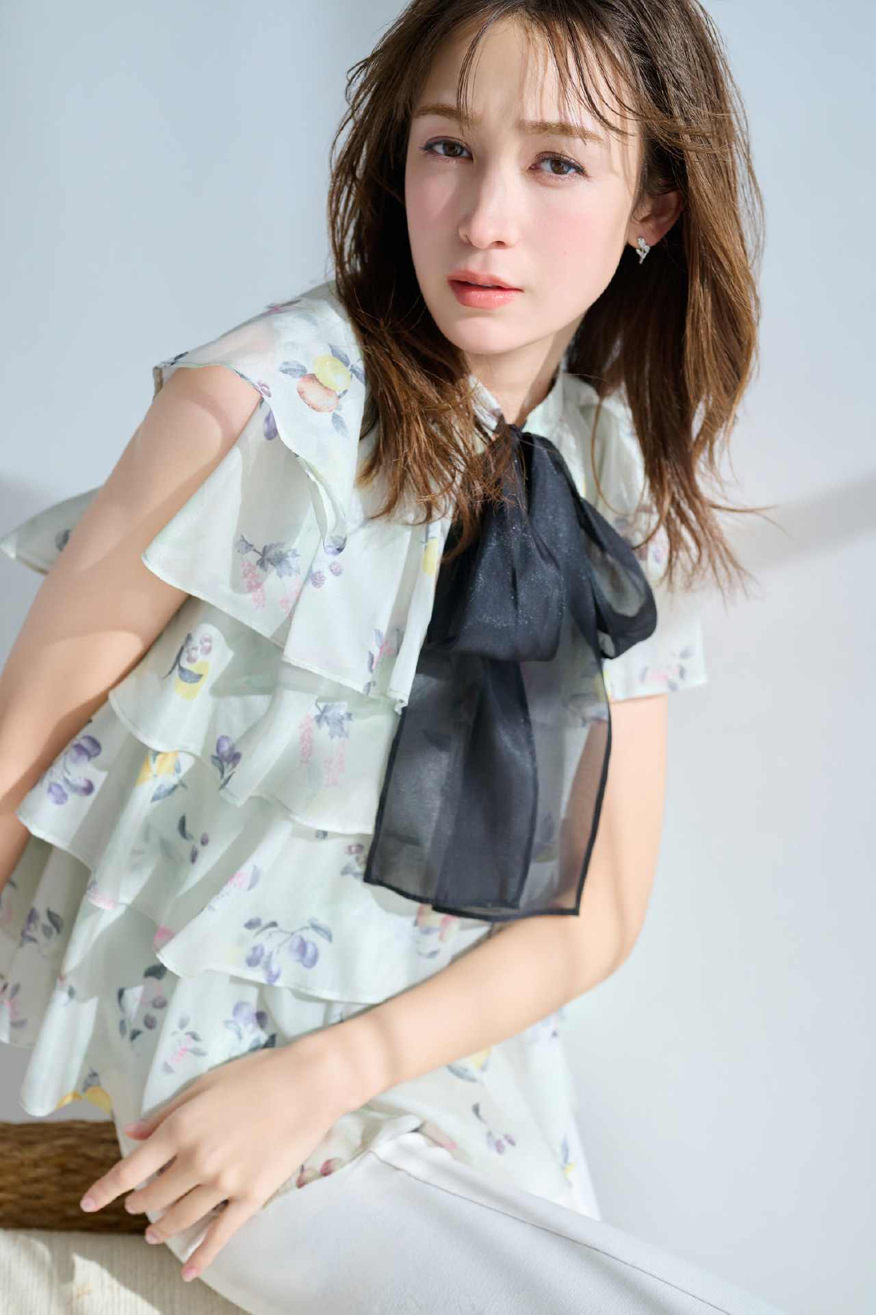 ミント色のフルーツプリントティアードブラウスを着用したモデル画像