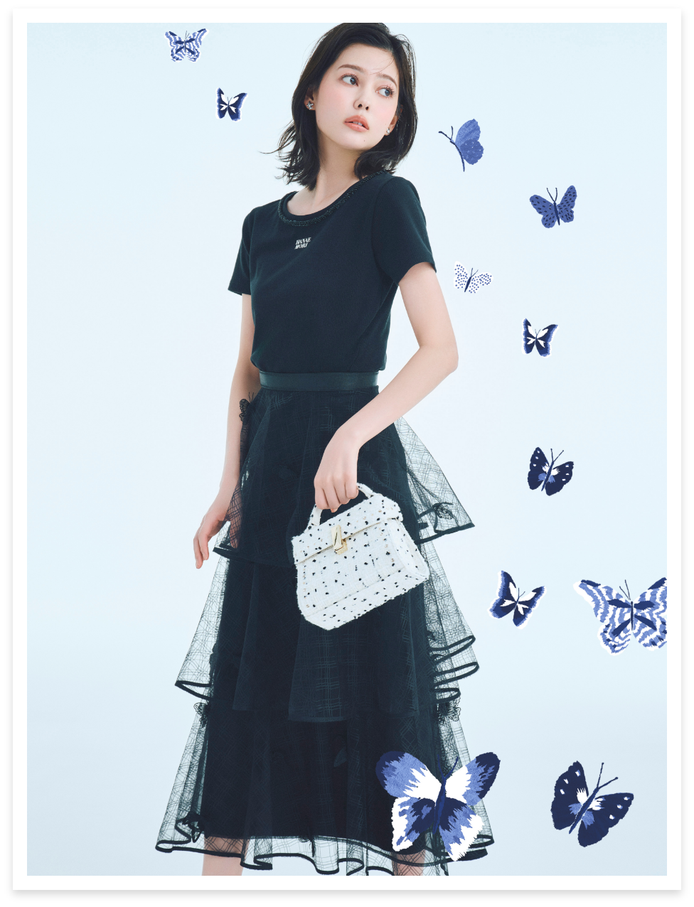 【HANAE MORI×CELFORDコラボ】ロゴカットトップス、【HANAE MORI×CELFORDコラボ】バタフライモチーフティアードスカート、ビジュースタッズツイードポシェット、バレエビジュースニーカーを着用した女性のイメージ